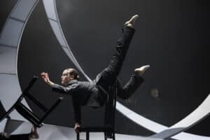 Tänzerin balanciert mit Stühlen in Tanzproduktion "Zeit" am Theater Osnabrück. Foto: Oliver Look