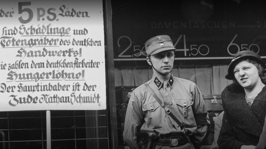 Ein Foto aus der Reichhauptstadt Berlin: SA-Mann präsentiert ein Plakat, das sich vermeintlich für Handwerksinteressen einsetzt - durchaus mit Resonanz.